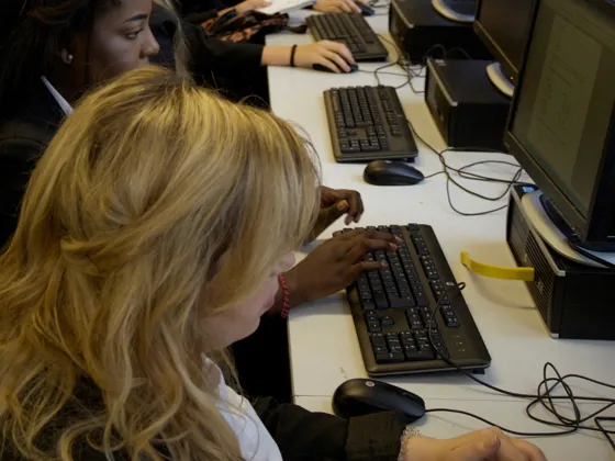 A row of pupils at desks in an ICT class