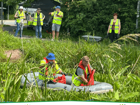 Volunteers in an inflatable boat clearing water soldier plants from a section of the canal at Two Locks