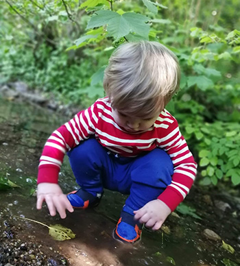 Child playing with leaf in water