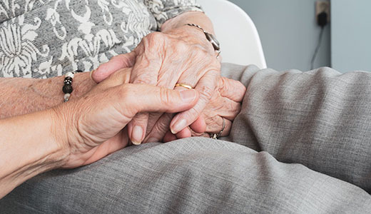 Hands together on the lap of an elderly person