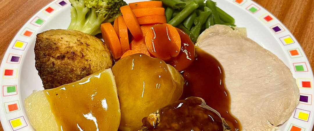 Pork loin served with roast and boiled potatoes, veg selection and gravy