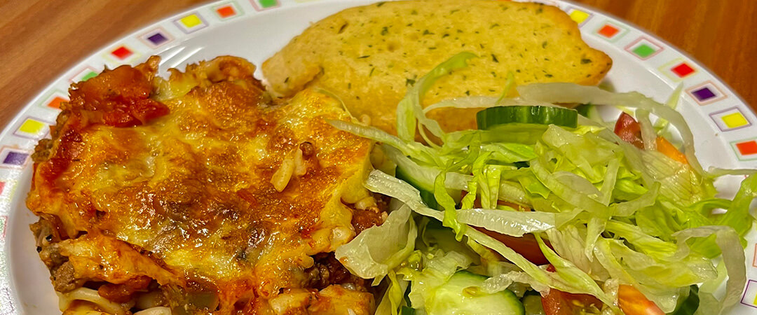 Quorn and vegetable pasta bake (V) served with salad and garlic bread