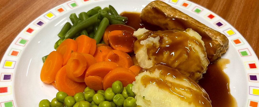 Quorn sausage (Ve) served with stuffing, seasonal vegetables, roast and boiled potatoes and gravy