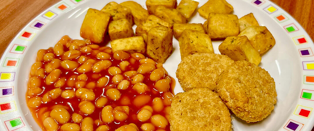 Vegetable nuggets (Ve) served with herby diced potatoes and baked beans