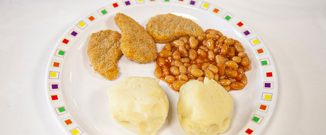 Breaded vegetable nuggets with potato wedges and baked beans