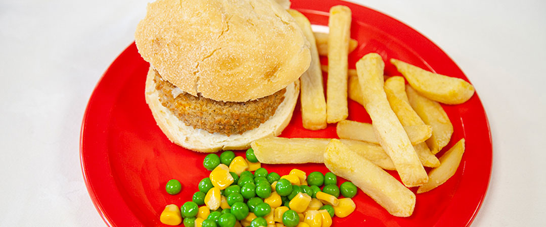 Quorn burger in a bun with chips and salad
