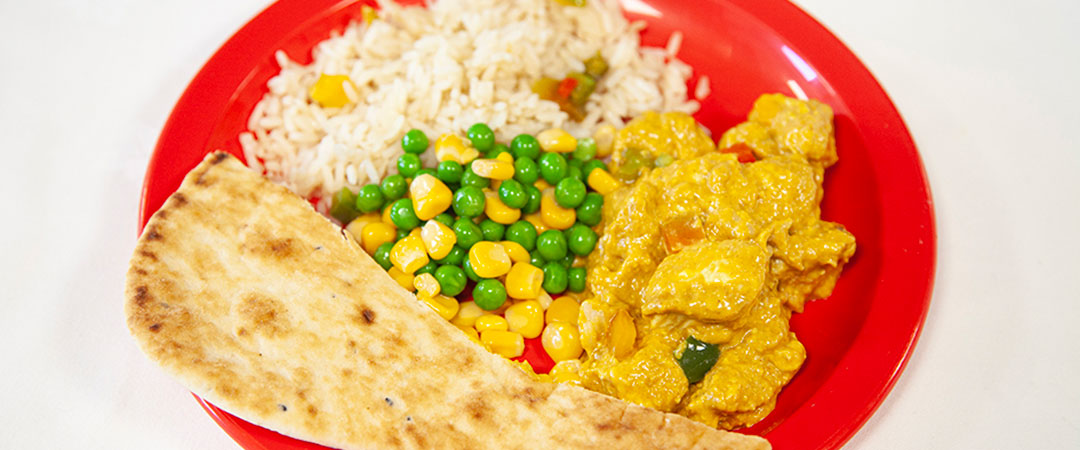 Vegetarian curry with savoury rice, seasonal vegetables and naan bread