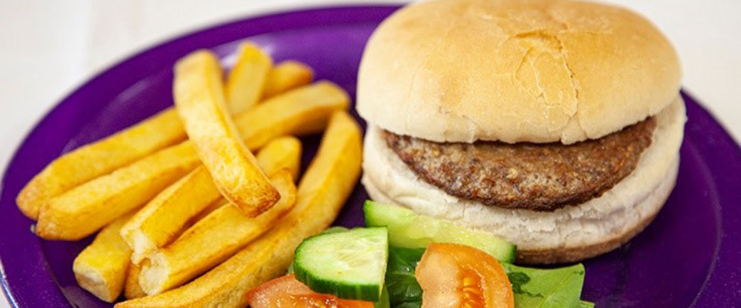 Beefburger in a Bun with Chips and Vegetables
