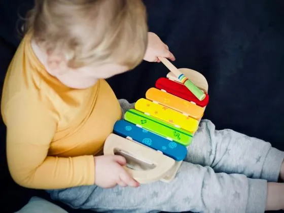 Child playing with colourful toy xylophone (Unsplash - Jelleke Vanooteghem)