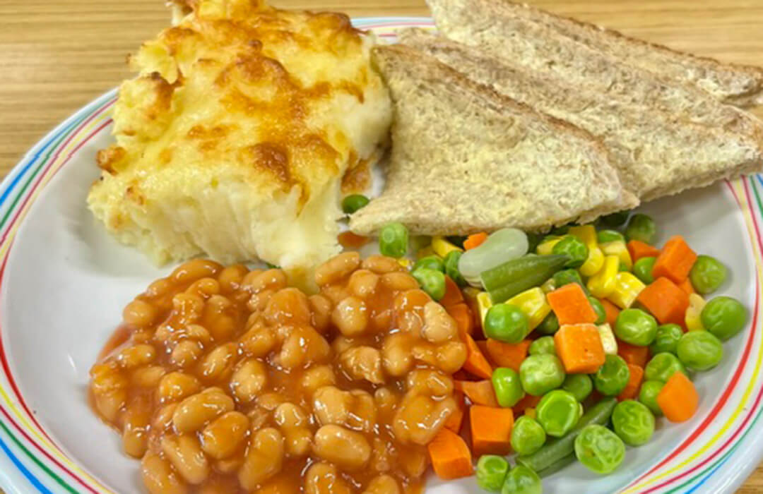 Cheese and potato pie served with mixed vegetables, broccoli and bread and spread