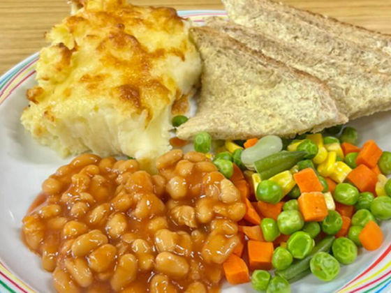 Cheese and potato pie served with mixed vegetables, broccoli and bread and spread