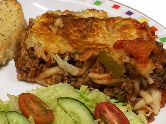 Homemade lasagne served with garlic bread and salad