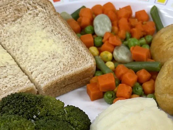 Quorn nuggets (Ve) served with herby diced potatoes, peas, bread and spread