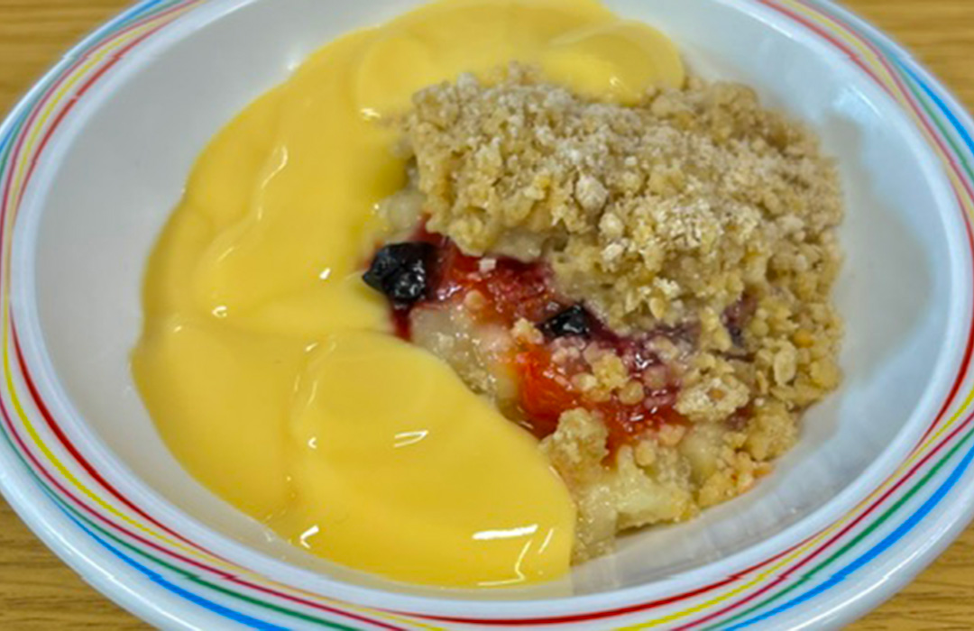Fruit crumble served with custard