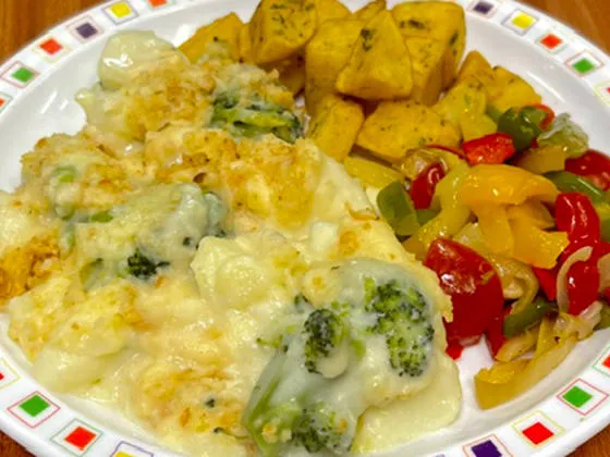Broccoli and potato bake with a garlic crumb (V) served with Mediterranean roasted vegetables