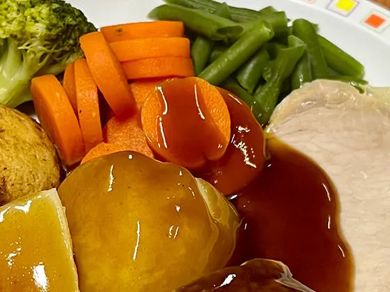 Pork loin served with roast and boiled potatoes, veg selection and gravy