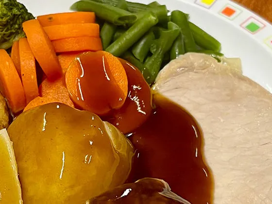 Pork loin served with roast and boiled potatoes, veg selection and gravy