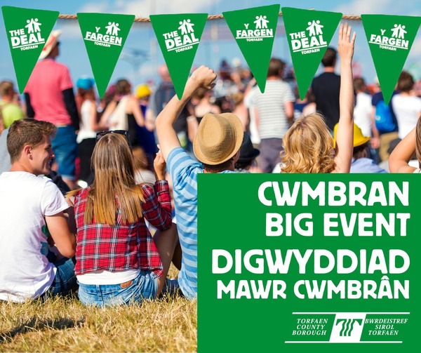 People sitting on bales of hay at an event with branding advertising Cwmbran Big Event