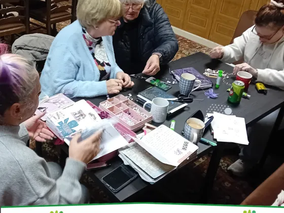 A group of women taking part in a journalling session around a table.