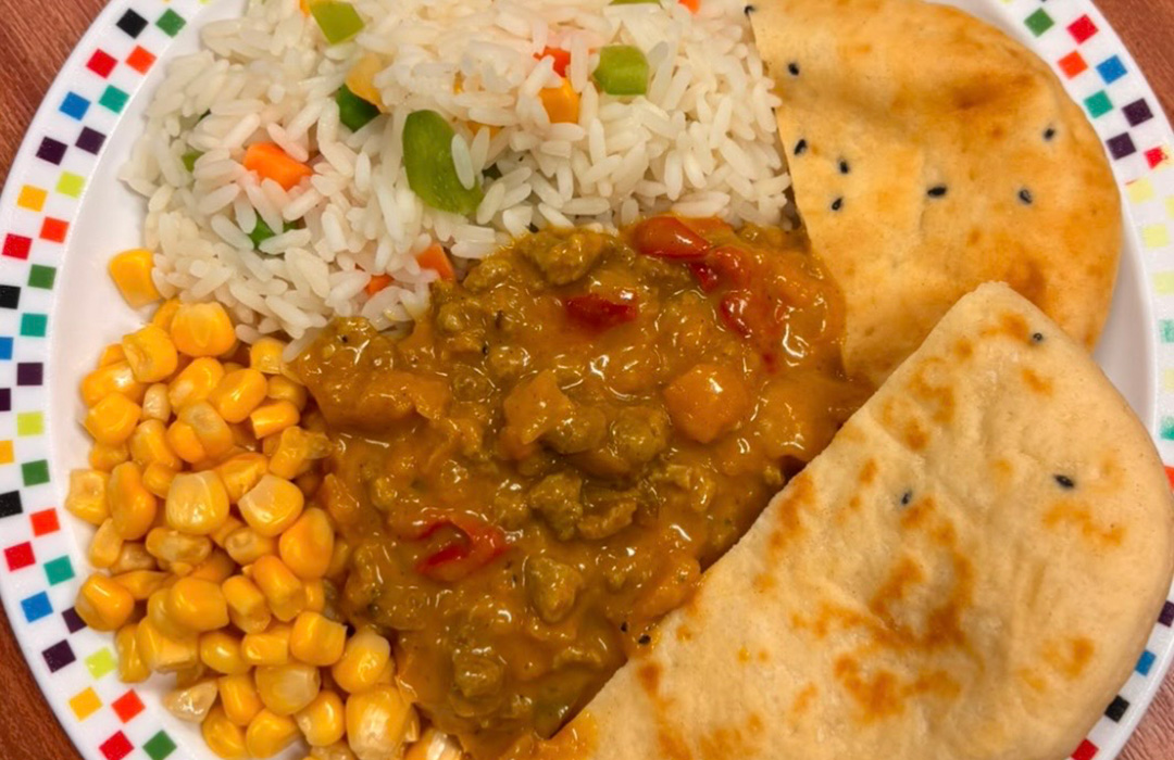 Keema curry served with savoury vegetable rice, sweetcorn and naan bread