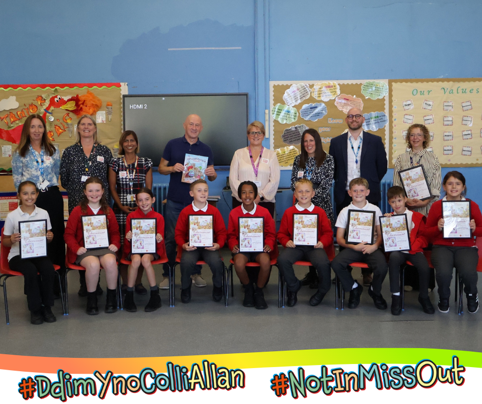 A group of pupils each holding up a copy of the books artwork, alongside teachers and public health staff