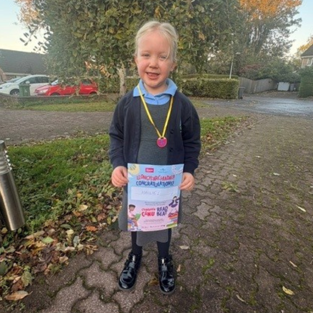 Year 1 pupil Hallie holding a certificate 