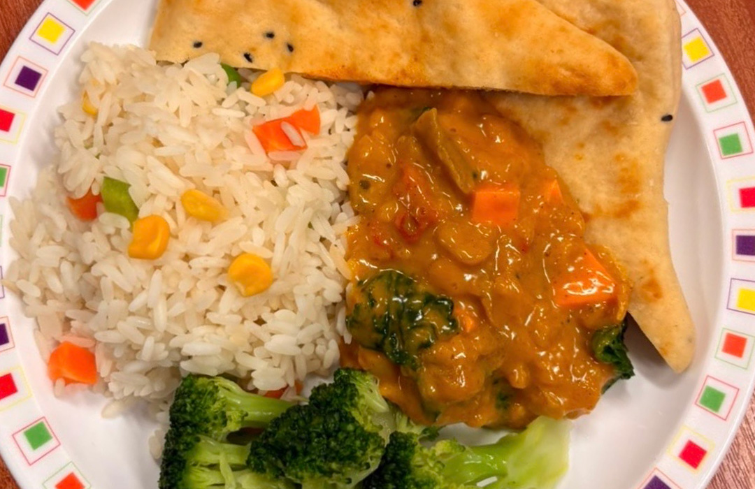 Sweet potato curry served with savoury vegetable rice, sweetcorn and naan bread 