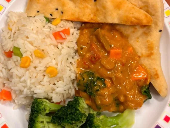 Sweet potato curry served with savoury vegetable rice, sweetcorn and naan bread