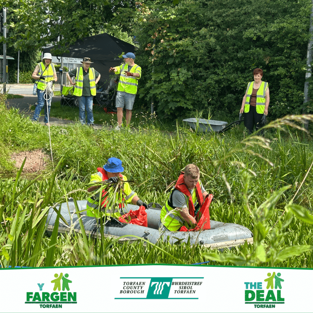 Volunteers in an inflatable boat clearing water soldier plants from a section of the canal at Two Locks